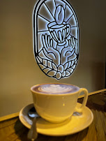 Taza de café frente al emblema de Cafeteras Coffee.